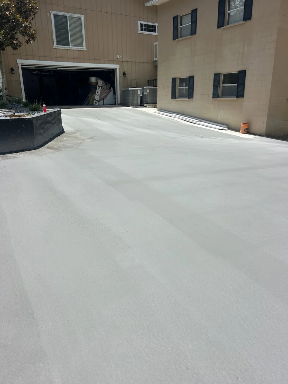 Newly installed concrete driveway with smooth finish in front of residential garage